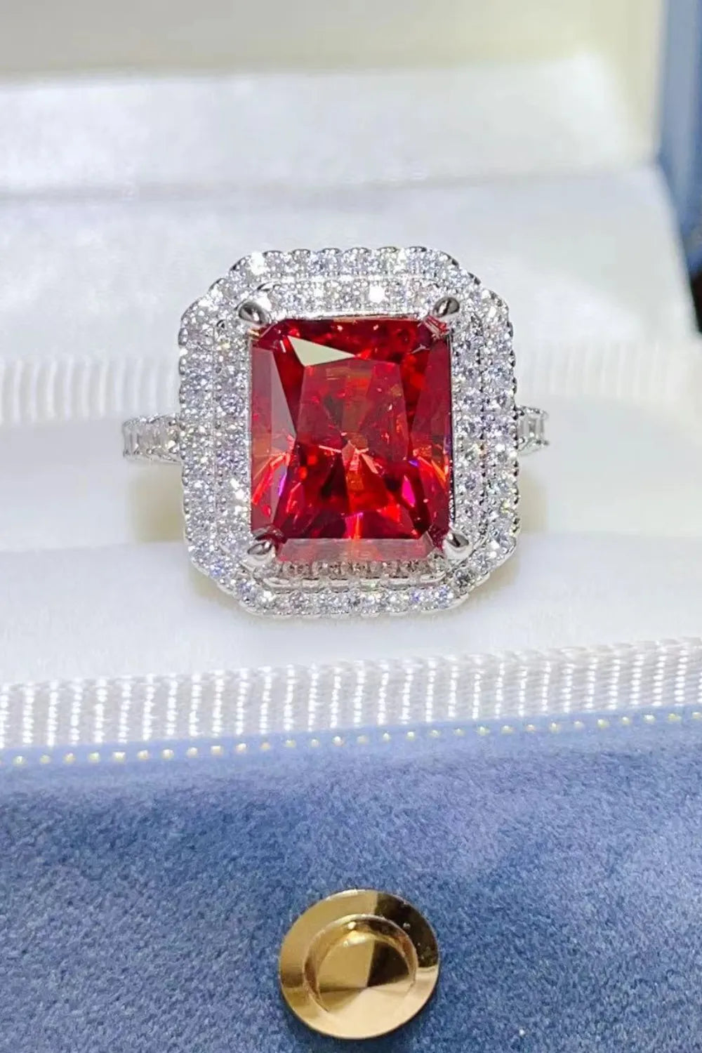 Radiant ruby halo cocktail ring in sterling silver with pave diamond accents.