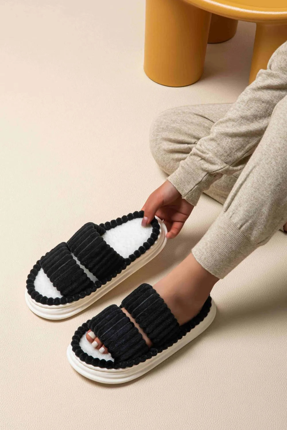 Black ribbed terrycloth platform slides with white fuzzy lining and beaded trim.