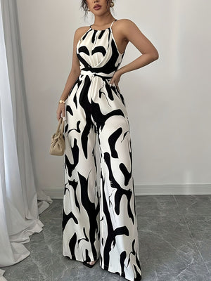 Elegant wide-leg jumpsuit with abstract black and white print, halter neck, and tie waist.