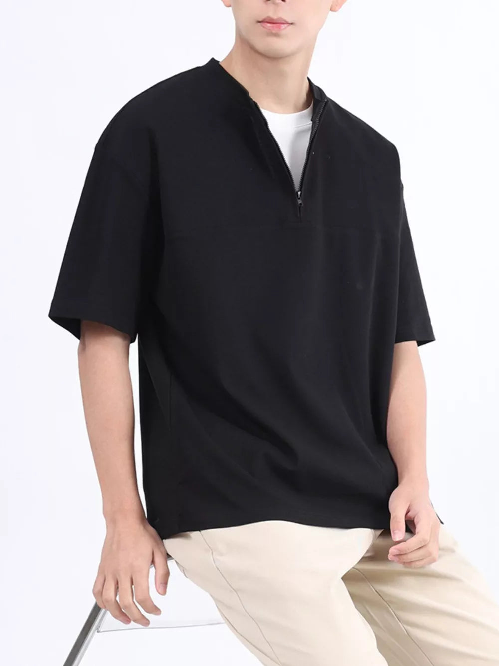 Black cotton half-zip t-shirt with a relaxed fit and short sleeves.