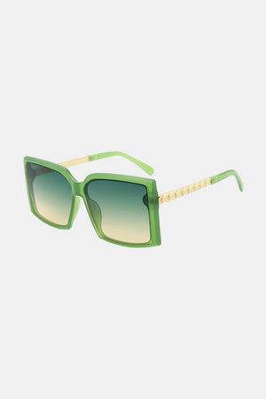 Green geometric sunglasses with gradient lenses and gold textured temples.