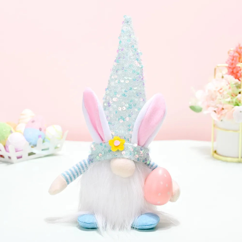 Easter Bunny Gnome with sequin cone hat, holding pink egg. Light blue gnome decor.