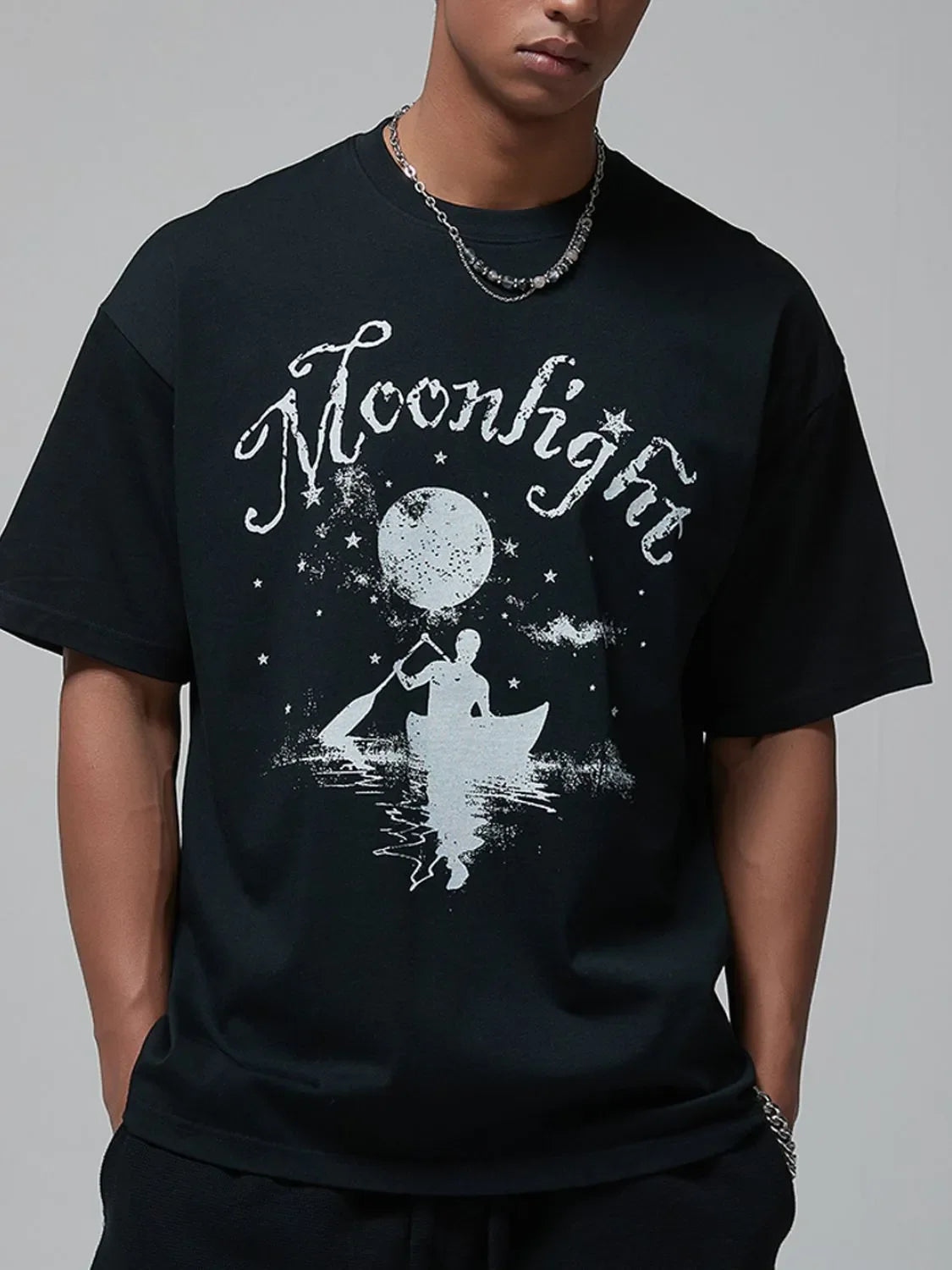 Black oversized graphic tee with a white moonlight and canoeist print.