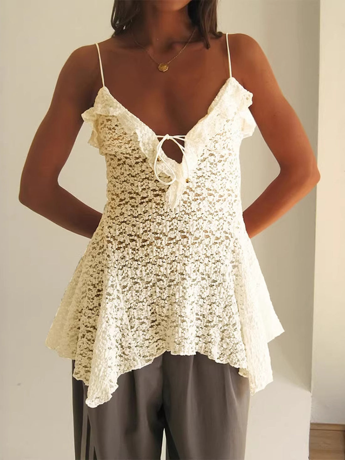 Lace ruffle tie-front cami top in beige with spaghetti straps and asymmetrical hem.