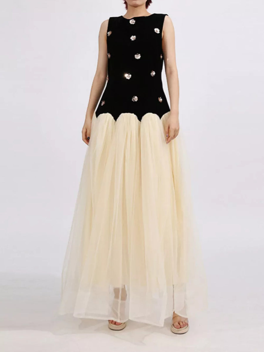 Black velvet sleeveless maxi dress with sequin floral detail and cream tulle skirt.