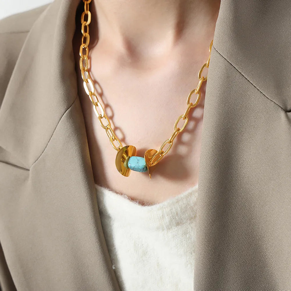 Geometric Malachite Pendant Necklace with 18K gold-plated chain and light blue stone detail.