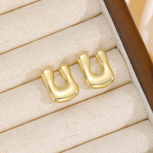 Gold sculpted alphabet earrings in a bubble style, copper material.