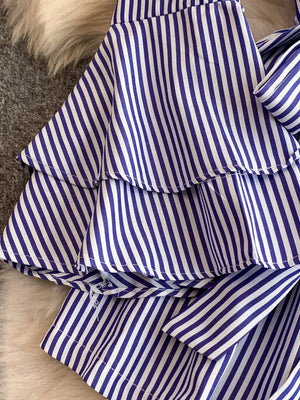 Blue and white striped romper with tiered ruffles and a bow detail.
