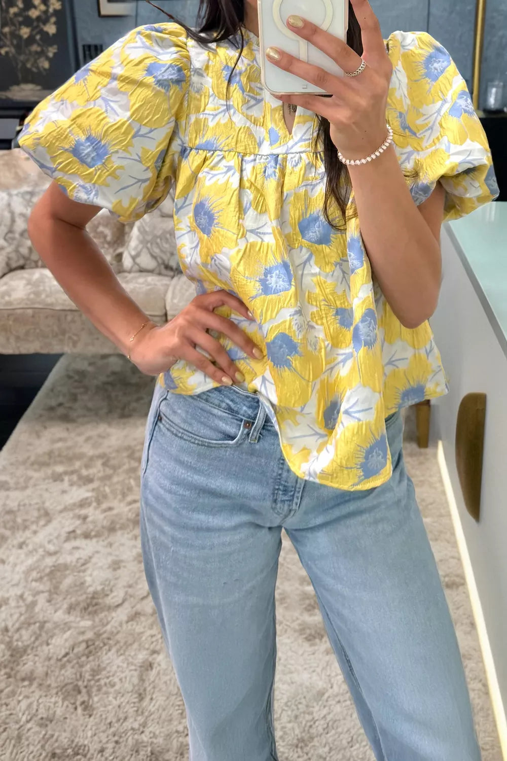 Yellow floral textured blouse with bubble sleeves and a v-neckline.