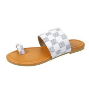 White checkered toe-loop flat sandals with a tan sole.