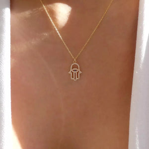 Gold evil eye hamsa pendant necklace with rhinestones on a delicate chain.