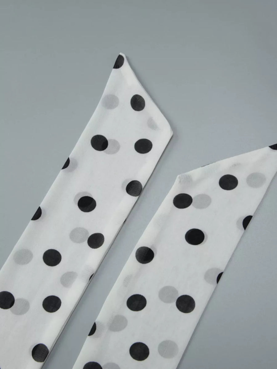 White and black polka dot mini dress with halter neck and ruched detail.