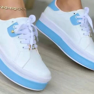 White and blue lace-up platform sneakers with gold accents and a thick sole.