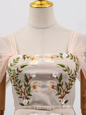 Embroidered midi dress with floral detail, square neckline, and sheer puff sleeves.