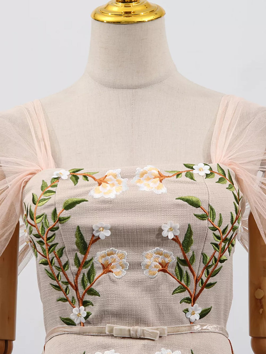 Embroidered midi dress with floral detail, square neckline, and sheer puff sleeves.