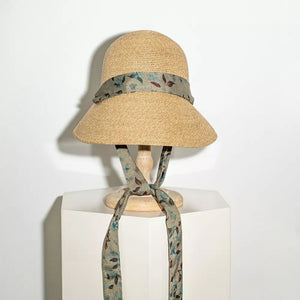 Straw sun hat with a floral ribbon and defined crown, tied at the front.