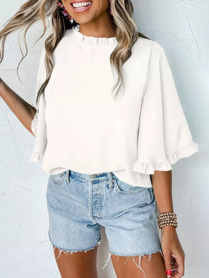 White ruffled mock neck half sleeve shirt with ruffled cuffs.
