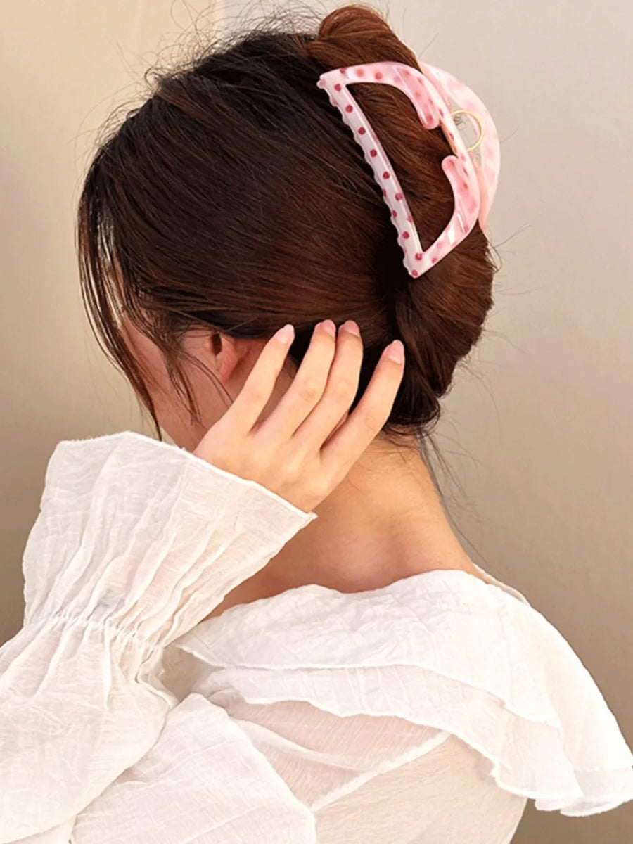 Polka dot claw hair clip in pink Style A, with a marble effect and gold accent.