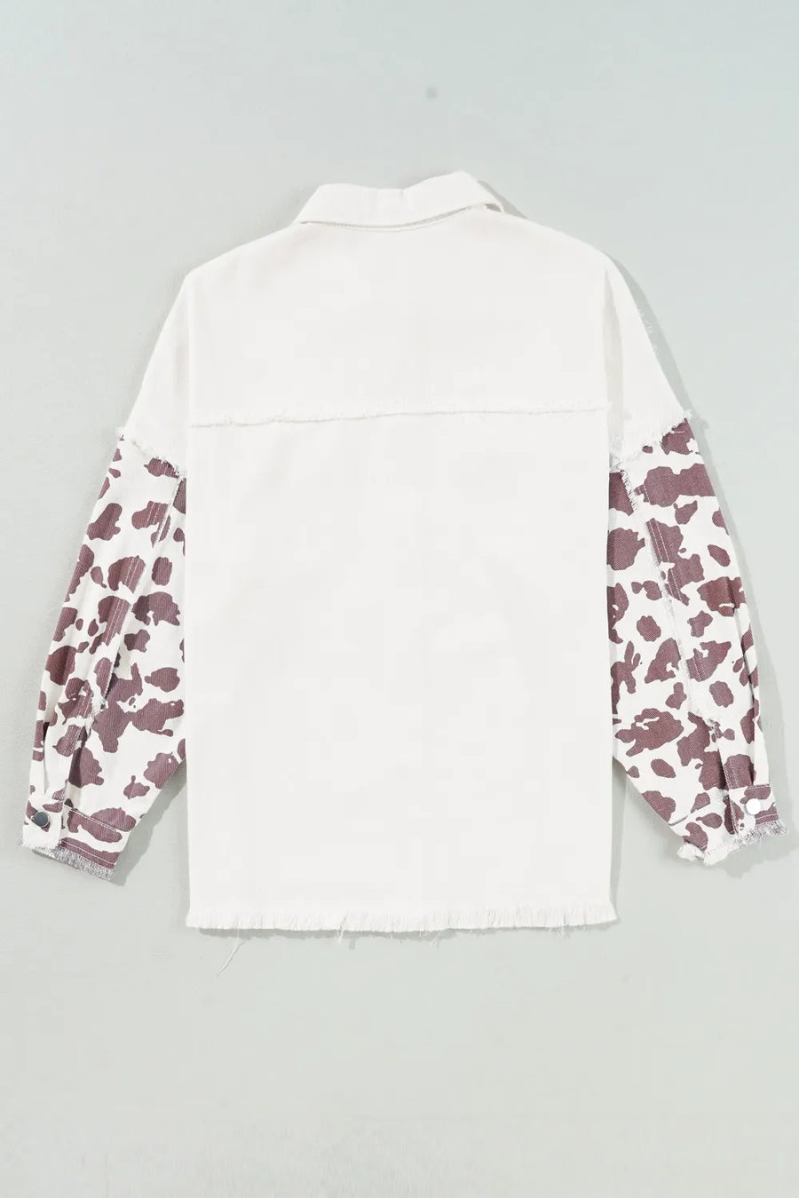 White denim shacket with cow print sleeves and frayed edges