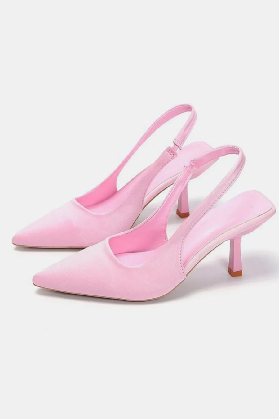 Blush pink satin slingback pumps with sculpted heels and pointed toes.