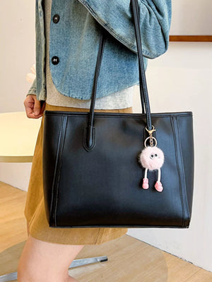 Black PU leather tote bag with a playful pink pompom charm.