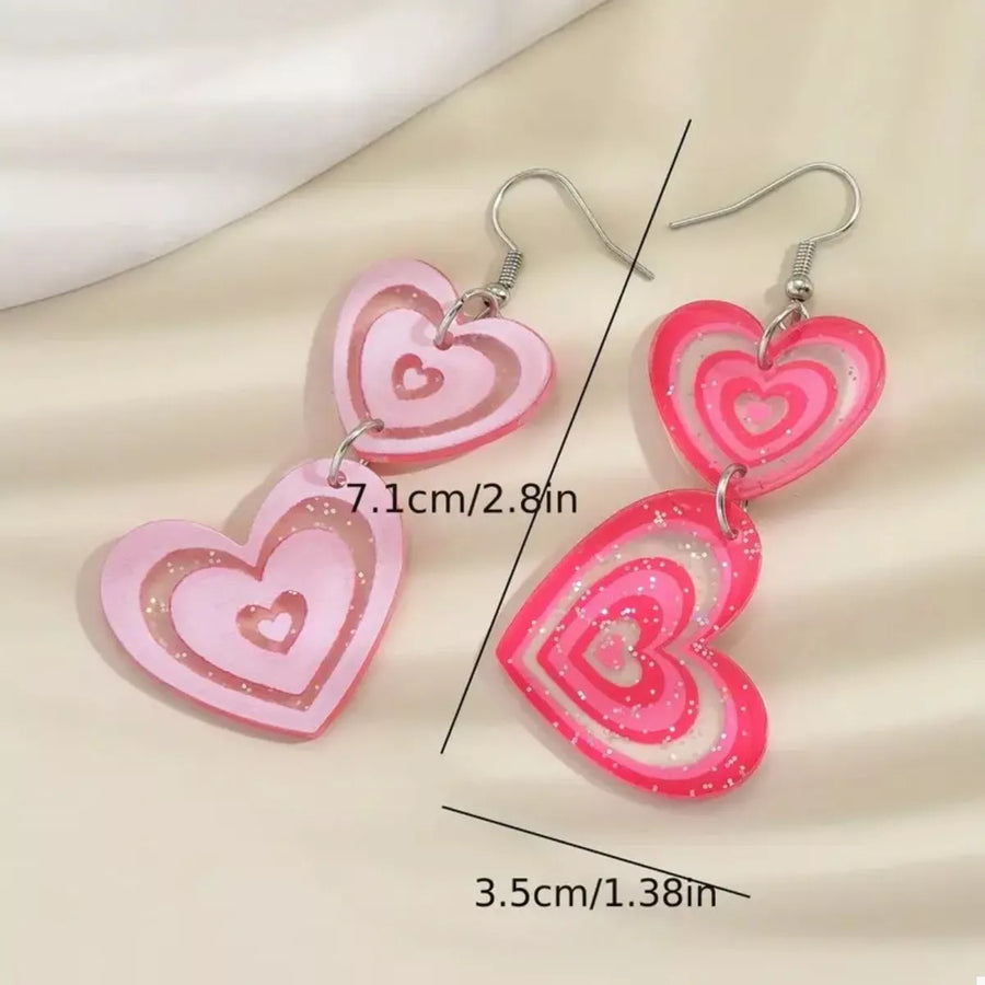 Pink acrylic heart dangle earrings with glitter detail