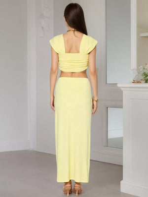 Yellow ruched crop top with cap sleeves and a square neckline, paired with a matching maxi skirt.