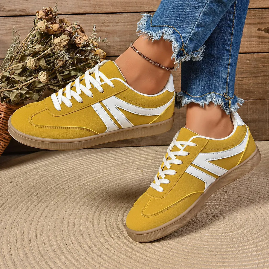 Yellow suede sneakers with white chevron detail and gum sole.