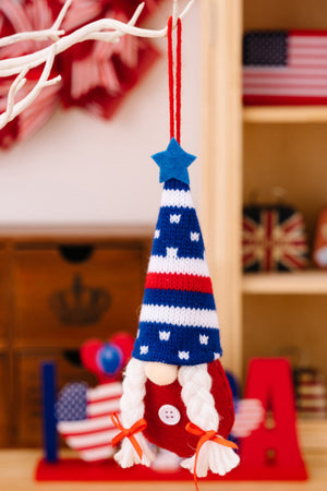 Patriotic knit gnome ornament with blue star hat, red and white striped body, and braided white pigtails.
