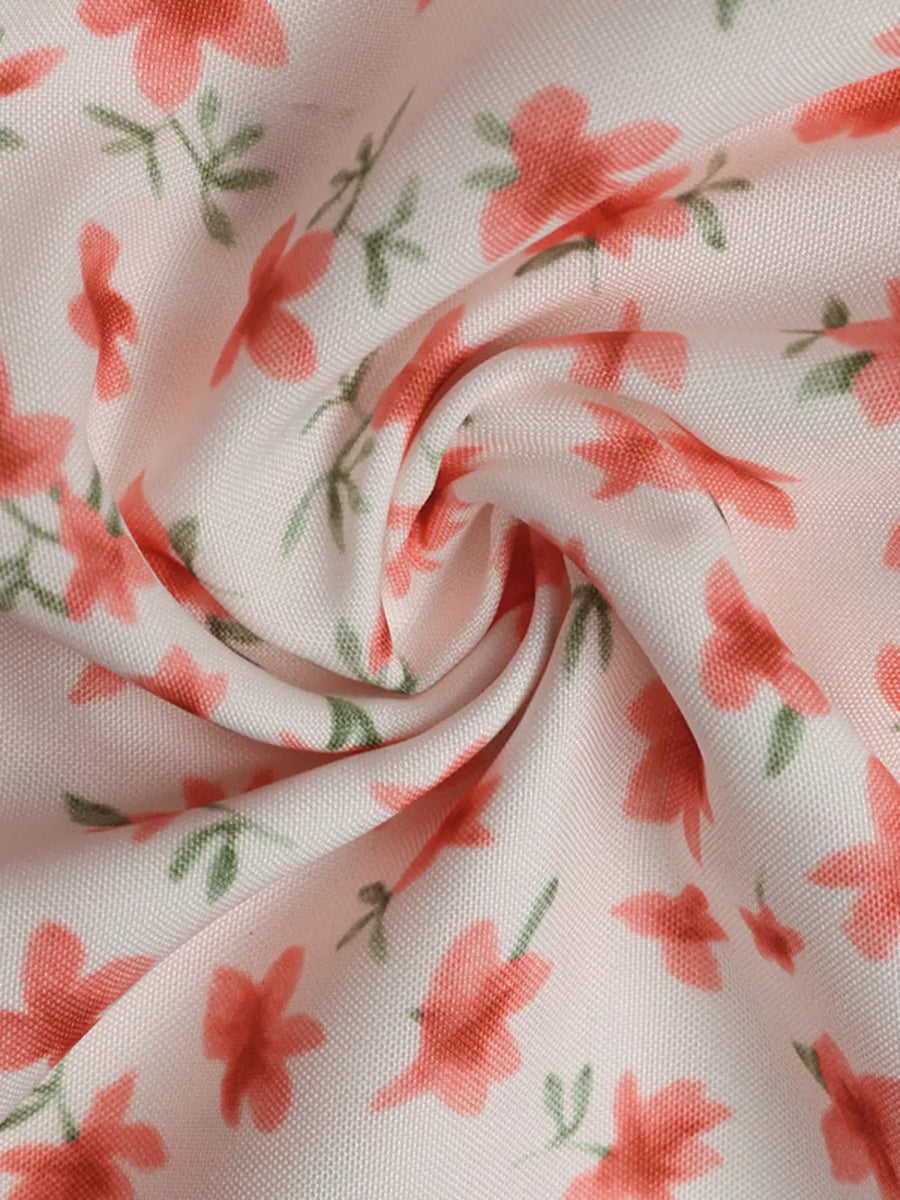 Floral mini dress with V-neck and puff sleeves in a light pink fabric with coral flowers and green leaves.