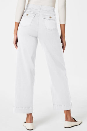 White wide-leg denim trousers with buttoned utility pockets and cuffed hems.