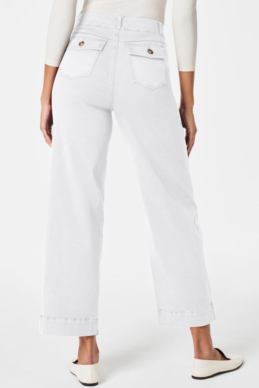White wide-leg denim trousers with buttoned utility pockets and cuffed hems.