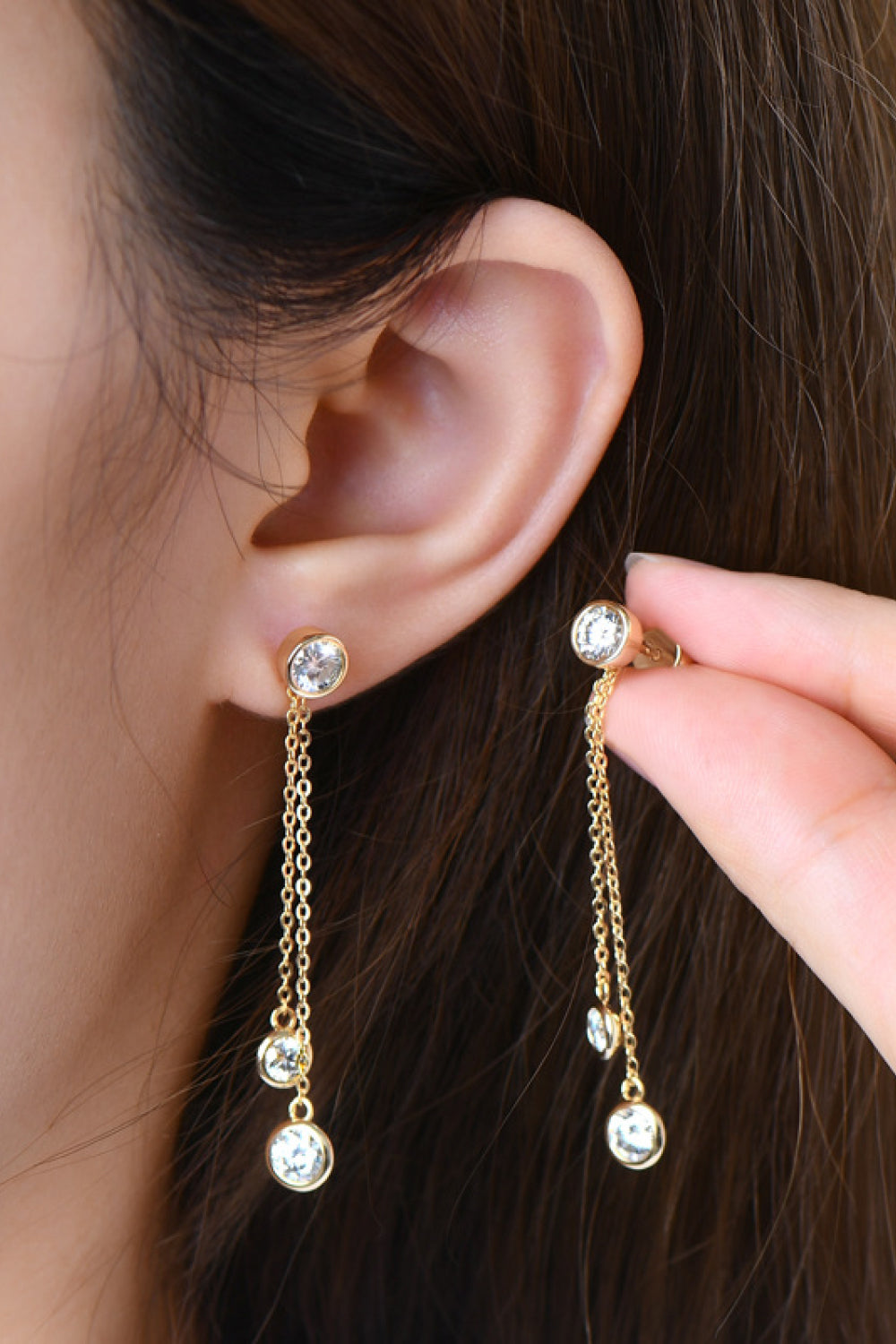 Gold cascade drop earrings with cubic zirconia stones and delicate chains.