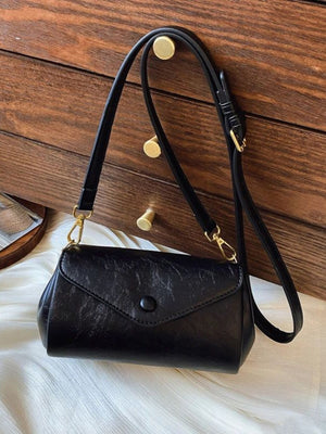 Black mini pu leather flap crossbody bag with button closure and gold hardware.