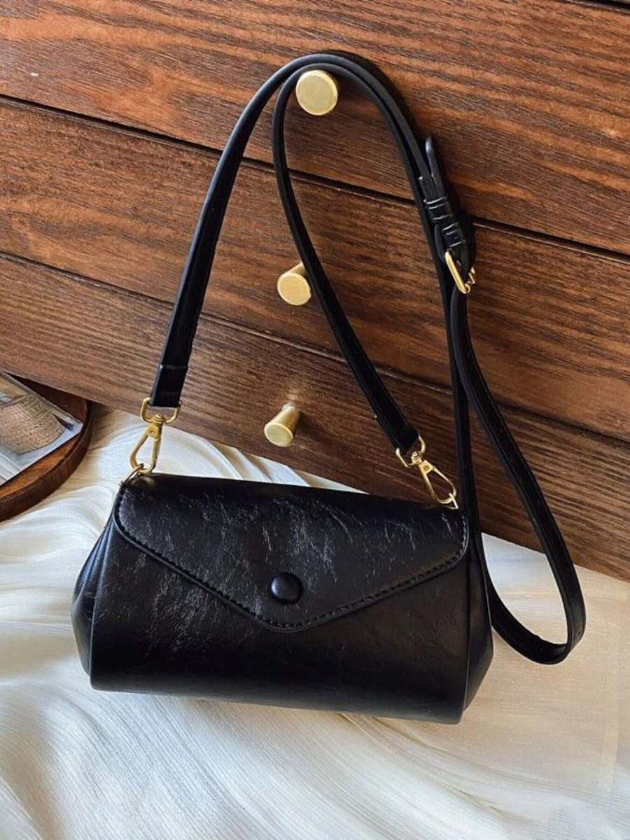 Black mini pu leather flap crossbody bag with button closure and gold hardware.