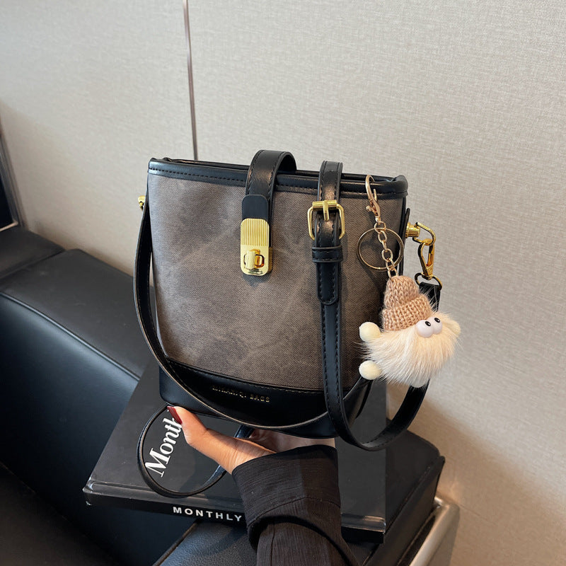 Vintage bucket crossbody bag in black with gold hardware and cute charm