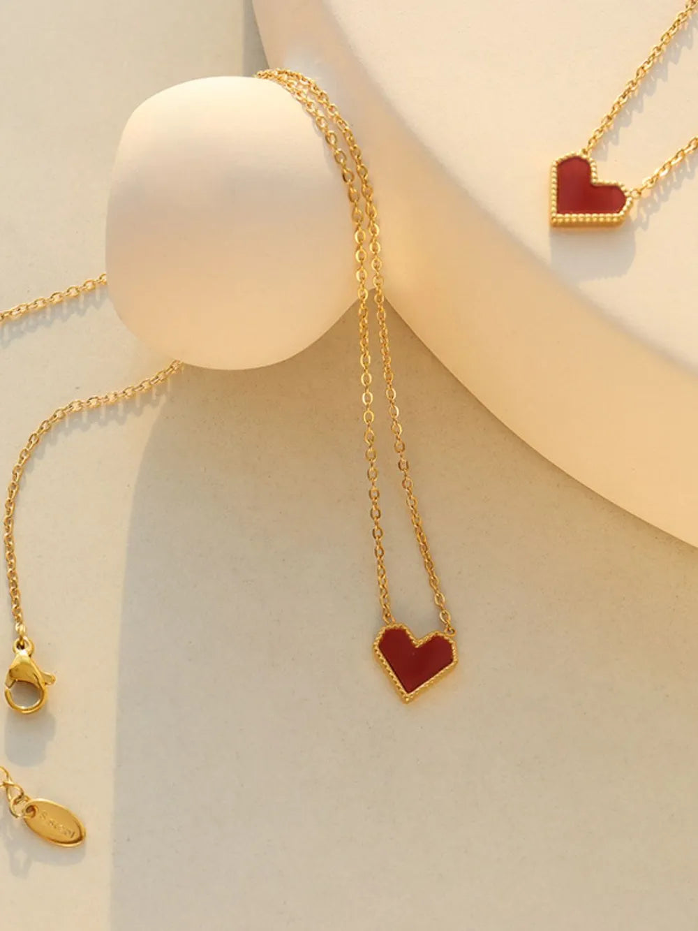 Gold necklace with a crimson heart pendant, 18K gold chain.