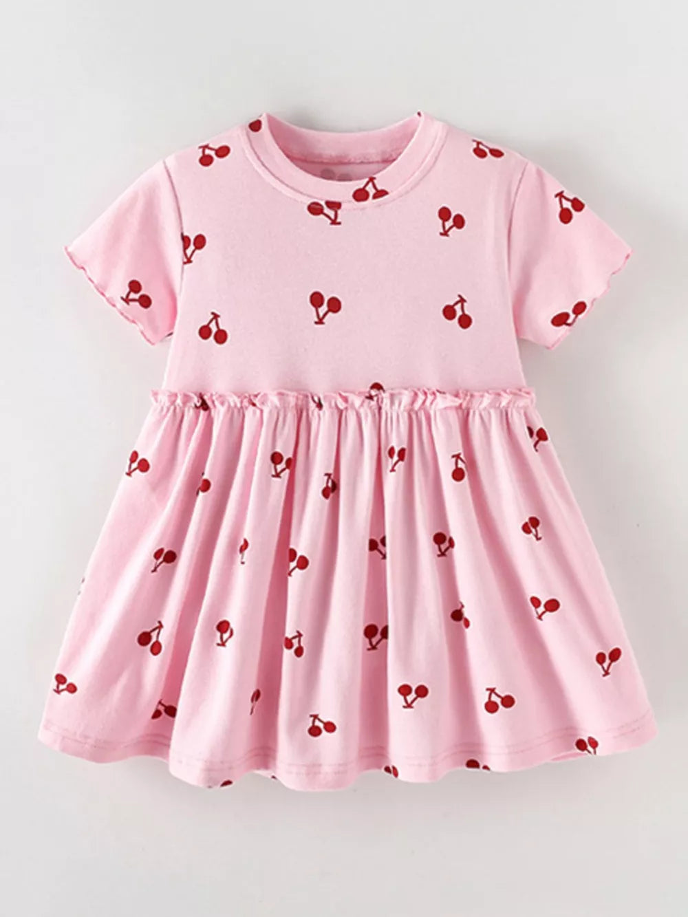 Baby dress in blush pink with a red cherry print, short sleeves, and ruffled waist.