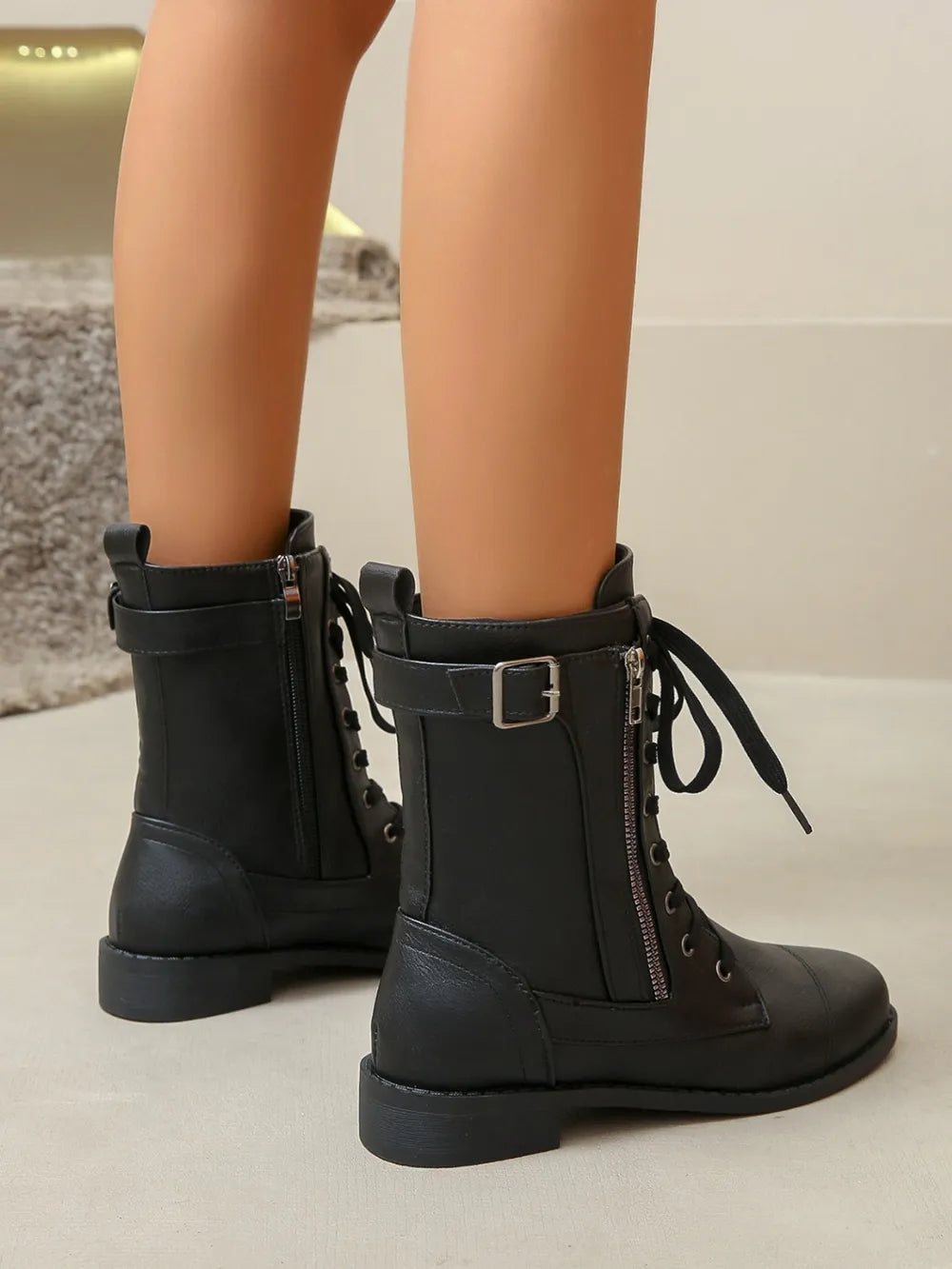 Black combat boots with side zipper and buckle detail.