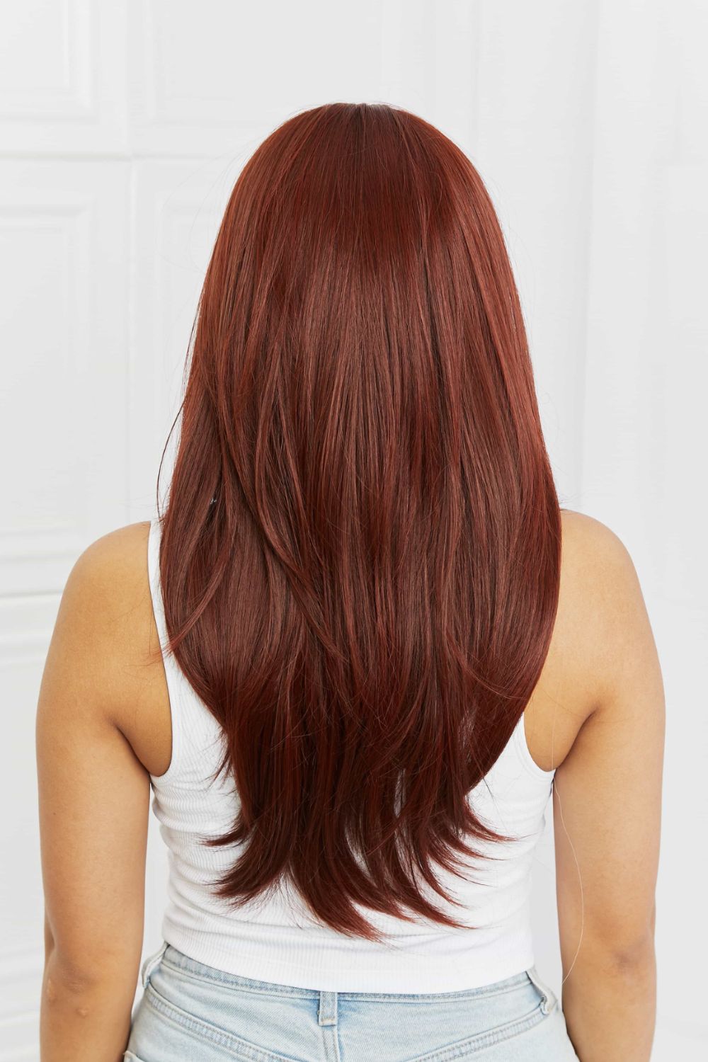 Layered copper red synthetic wig with subtle highlights, shown from the back.