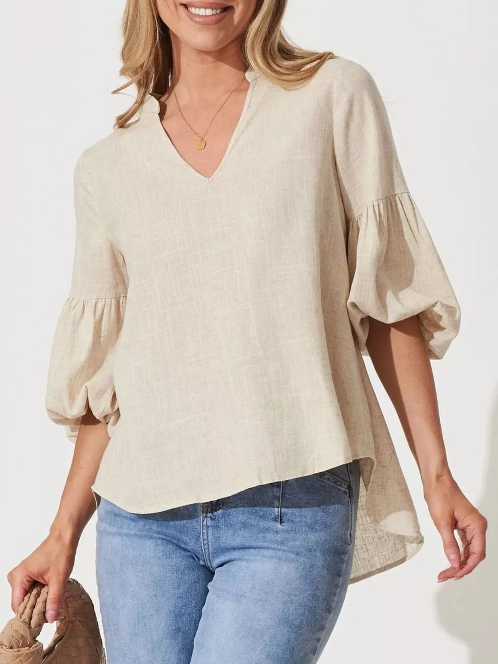 Maternity shirt with notched V-neck, balloon sleeves, and asymmetrical hem in natural linen-look fabric.
