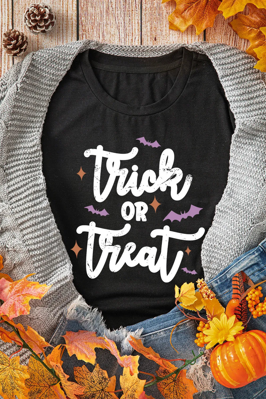 Black graphic t-shirt with white Trick or Treat text and purple bats.