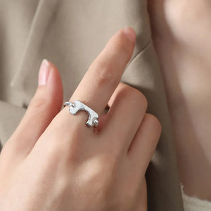 Silver open-ended ring with sculptural, asymmetric design.