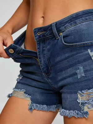 Dark blue denim shorts with distressed details and raw frayed hem