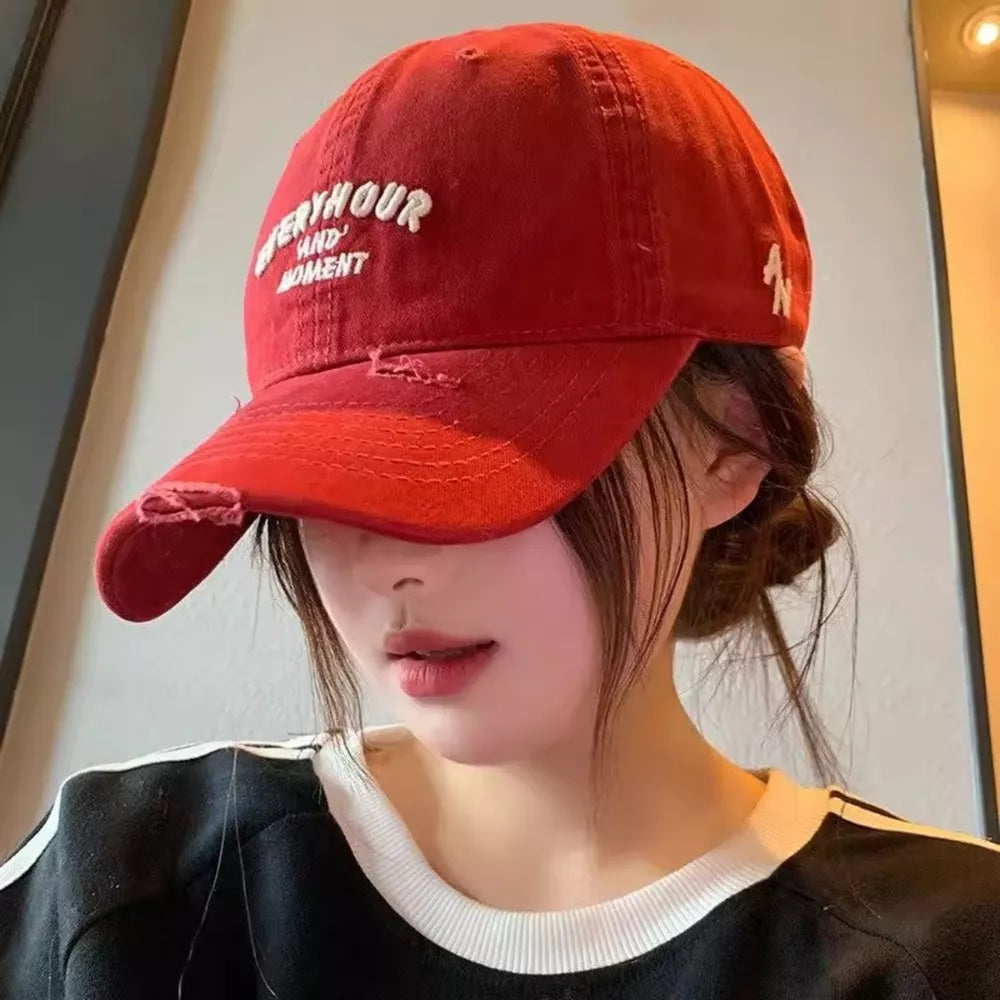Red distressed embroidered baseball cap with text detail