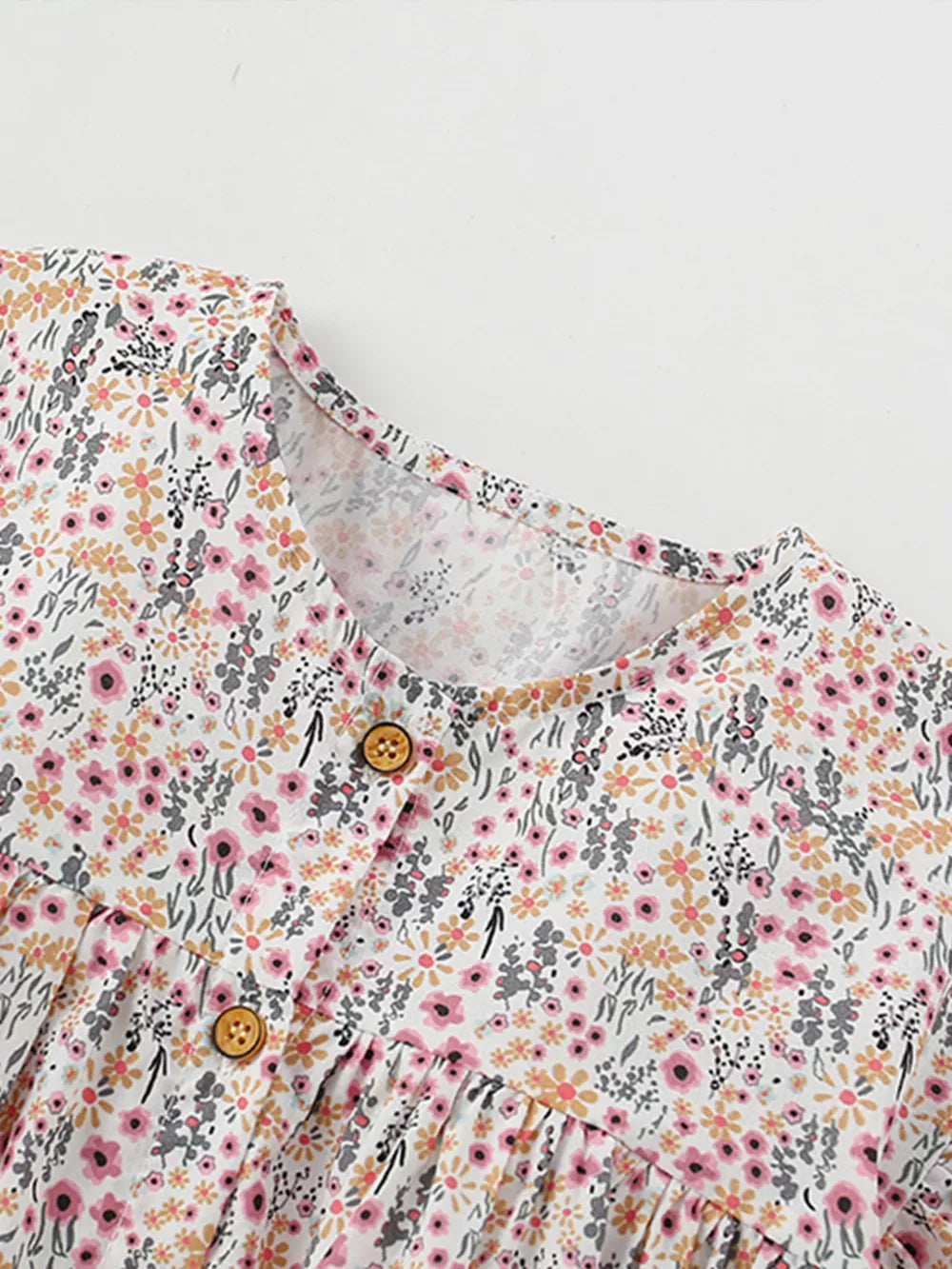 Toddler cotton dress with floral print, button front, and ruffle sleeves.