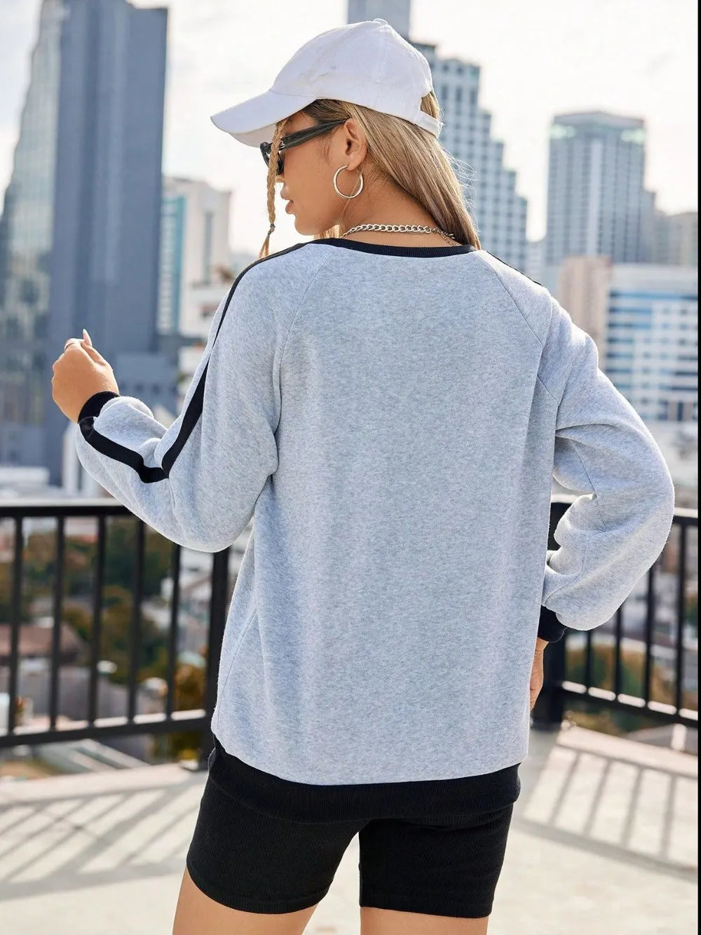 Light gray cotton sweatshirt with varsity stripes on sleeves and black trim.