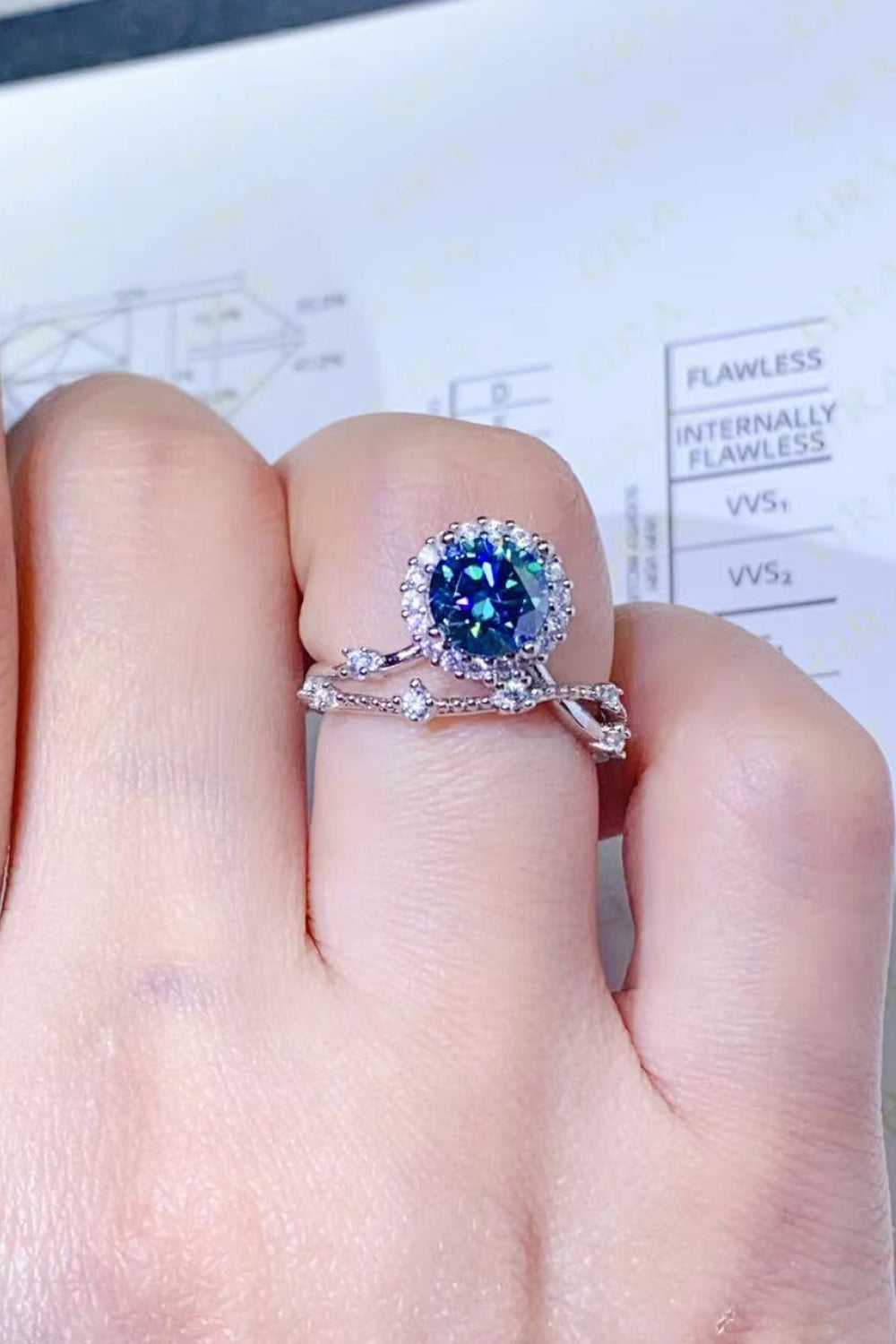 Sky blue moissanite halo engagement ring set with a matching band.