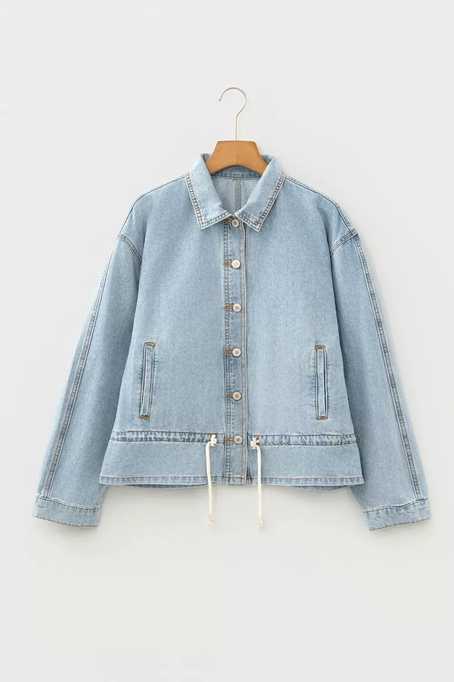 Light wash cotton denim jacket with button-down front and adjustable draw-cord hem