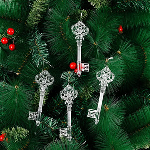 Clear crystal key Christmas ornaments hang on a green artificial tree with red berries.